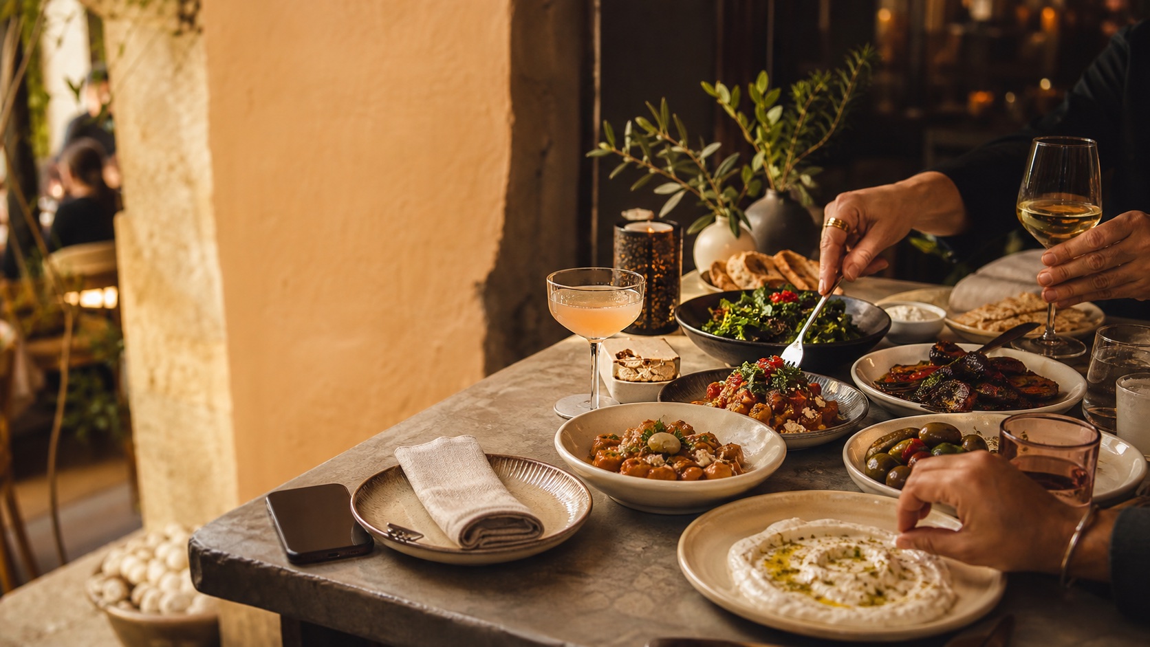 Friends sharing Mediterranean dishes at a restaurant table